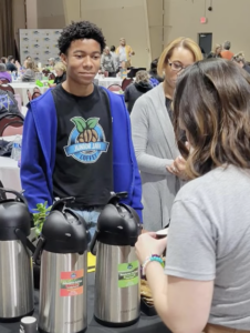 Noah Temple serving coffee to customers at MOSAC.
