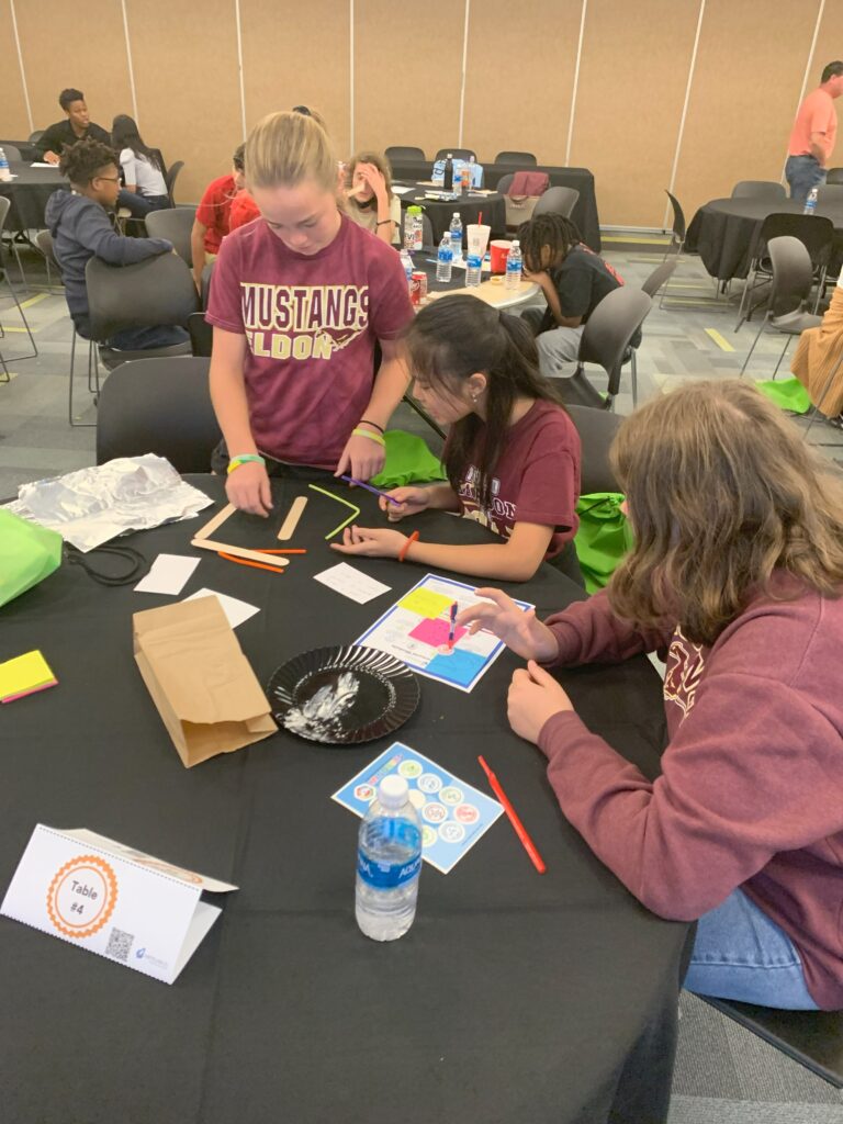 Three female students working at a table during the Middle School Leadership Summit